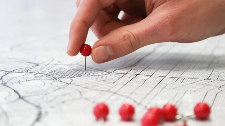 Hand placing a red pin on a local map, representing local SEO and Google Maps visibility